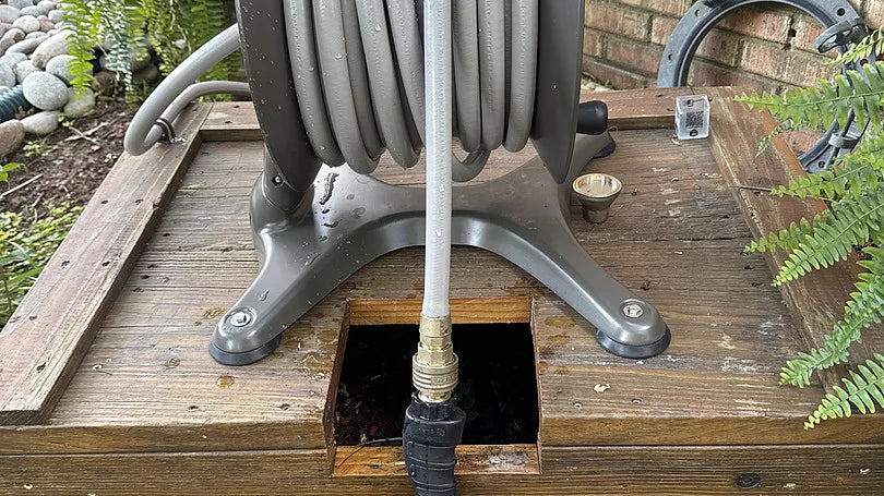 ELEY aluminum free-standing hose reel installed on a raised wood garden platform.