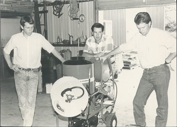 ELEY founders with early pressure washer hose reel system, black-and-white photo from 1992