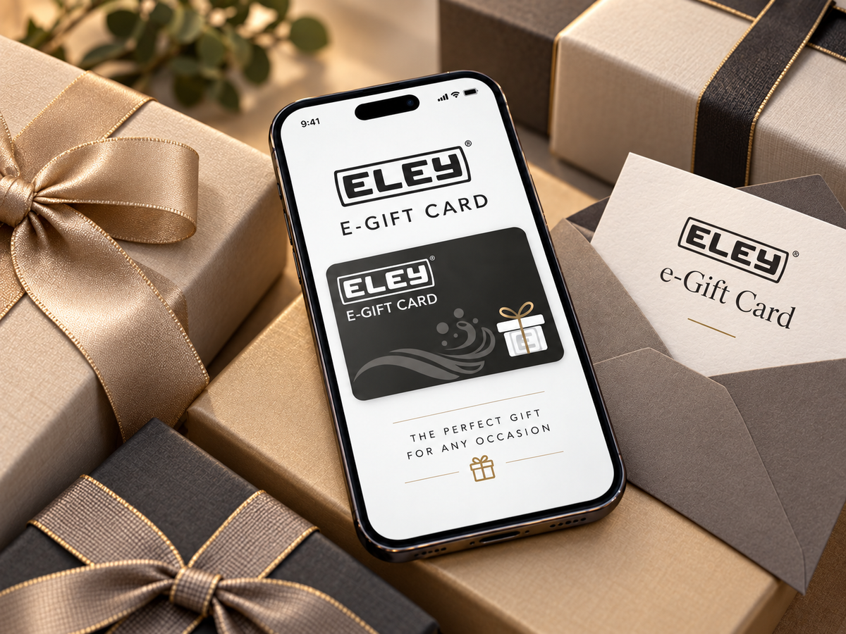 A smartphone displaying the ELEY E-Gift Card interface, surrounded by elegant gift boxes and envelopes in beige, brown, and black tones with gold ribbons.